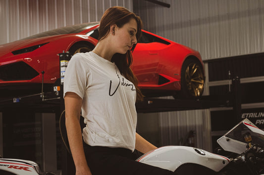 a woman sitting on a motorcycle in a garage