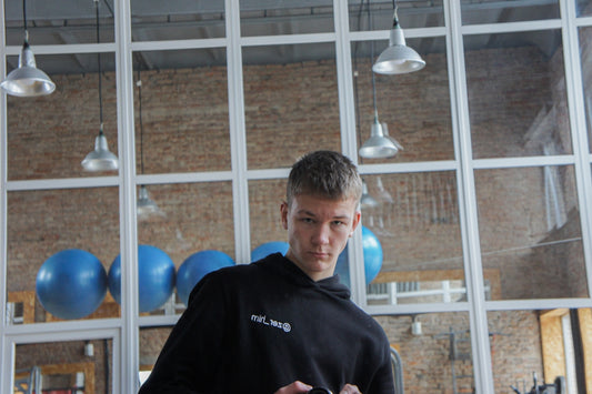 a man in a black hoodie holding a cell phone