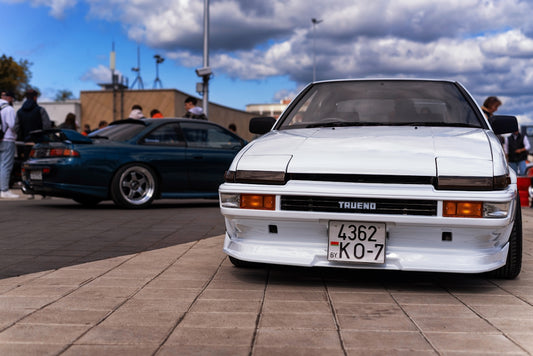 a white car parked in a parking lot next to other cars