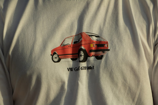 a man wearing a white shirt with a red car on it