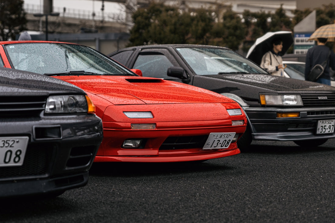 Three classic cars parked in a lot
