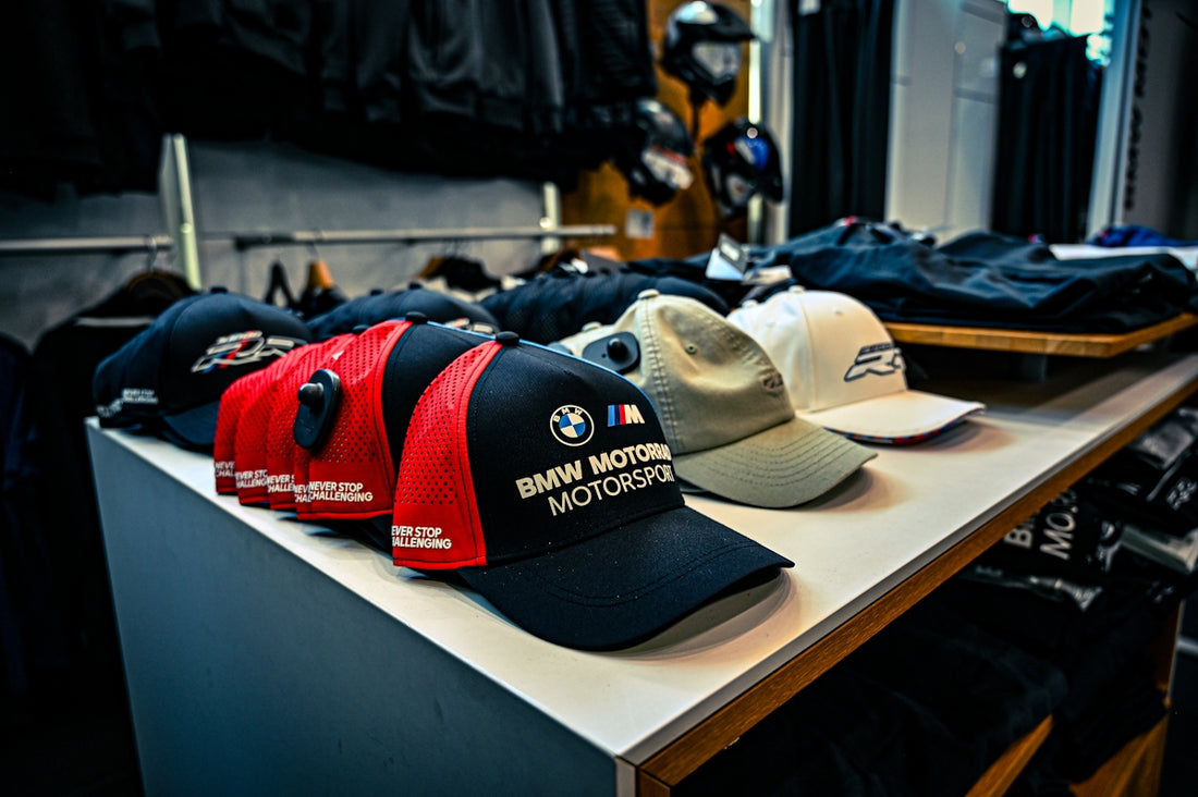 BMW motorsport baseball caps displayed on a store shelf.