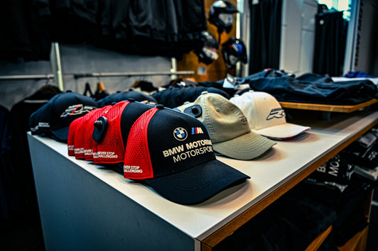 BMW motorsport baseball caps displayed on a store shelf.